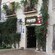 The front of a building near trees, bushes, vines and a sign that reads Bodega Bar El Pimpi